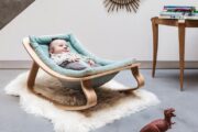 picture of a baby in a wooden bouncer seat