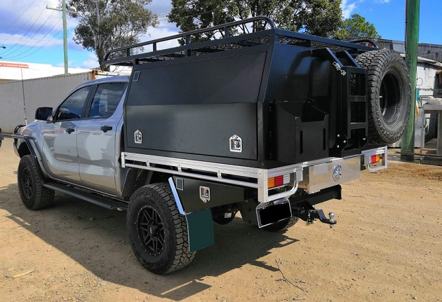 picture of an ute with a black canopy on a road