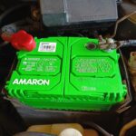 Close-up view of an installed Amaron car battery, highlighting its green casing and robust build, ensuring long-lasting power and reliability.
