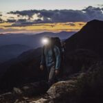 man wearing head torch on a mountain