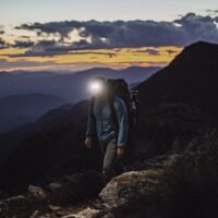 man wearing head torch on a mountain