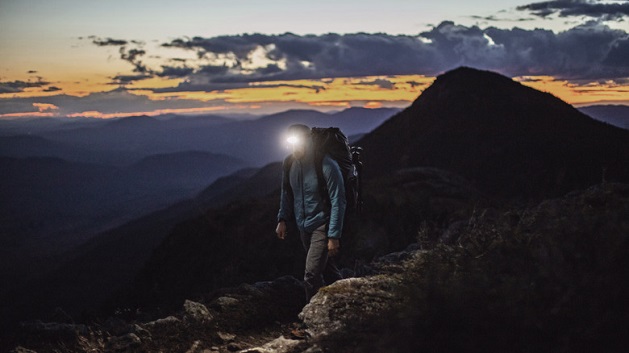 man wearing head torch on a mountain