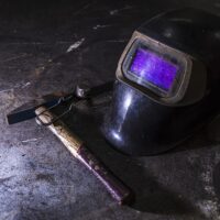 automatic welding helmet and a hammer