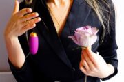 woman holding egg vibrator and a flower