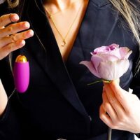 woman holding egg vibrator and a flower