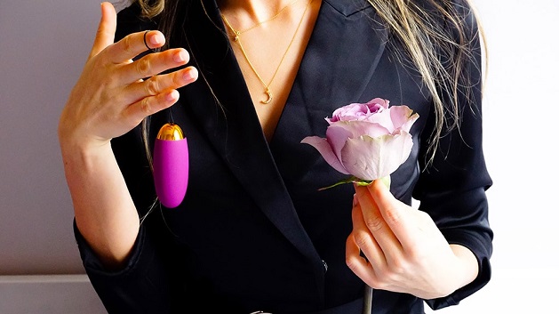 woman holding egg vibrator and a flower