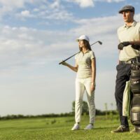 man and woman dressed for golf