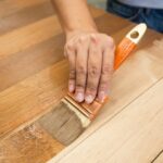 a person using a brush for wood staining